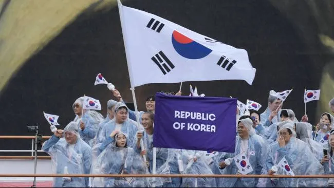 Kontingen Korea Selatan berada di atas perahu yang menyusuri Sungai Seine di Paris, Prancis, selama upacara pembukaan Olimpiade 2024, Jumat, 26 Juli 2024 atau Sabtu WIB. (Sumber: AP Photo)